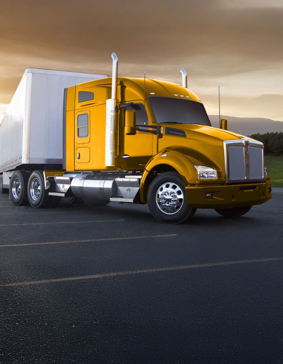 Gold Kenworth semi-truck at sunset — Freedom Carrier Service fleet